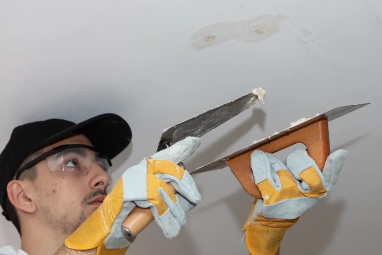 Un homme qui applique de l'enduit sur un plafond