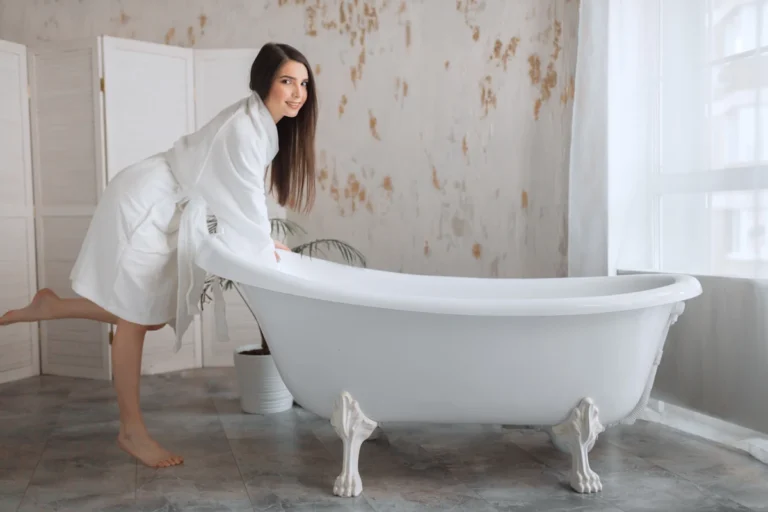 Une femme qui se tient contre unbaignoier blanc