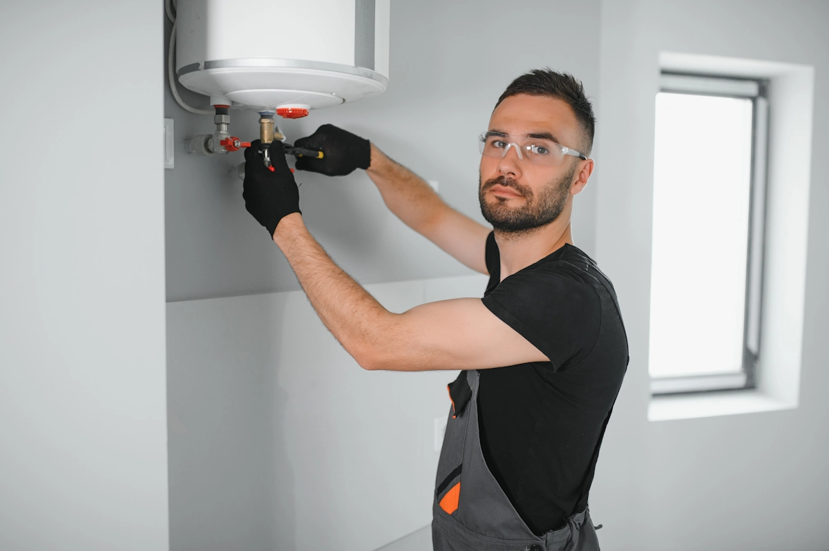 Un homme qui installe un chauffe-eau sur un mur