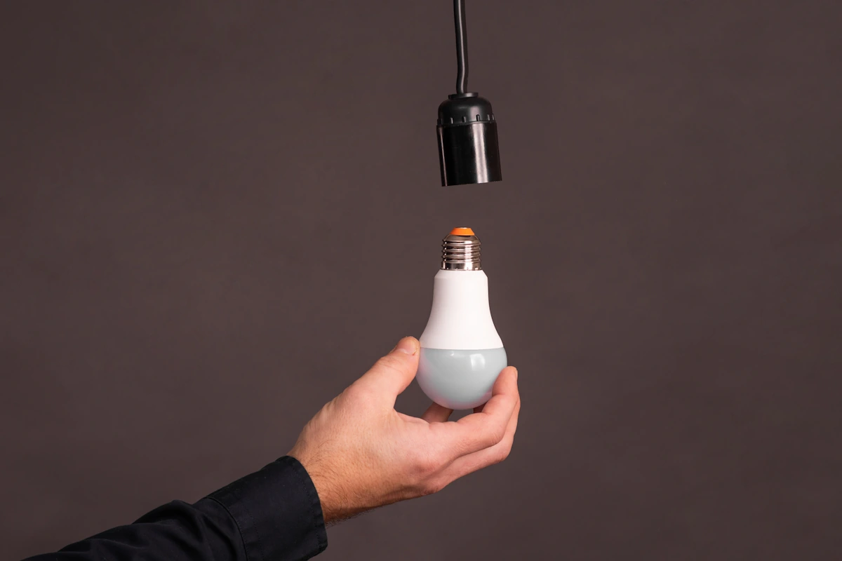 Une main qui tient une ampoule qui fait du bruit éteinte