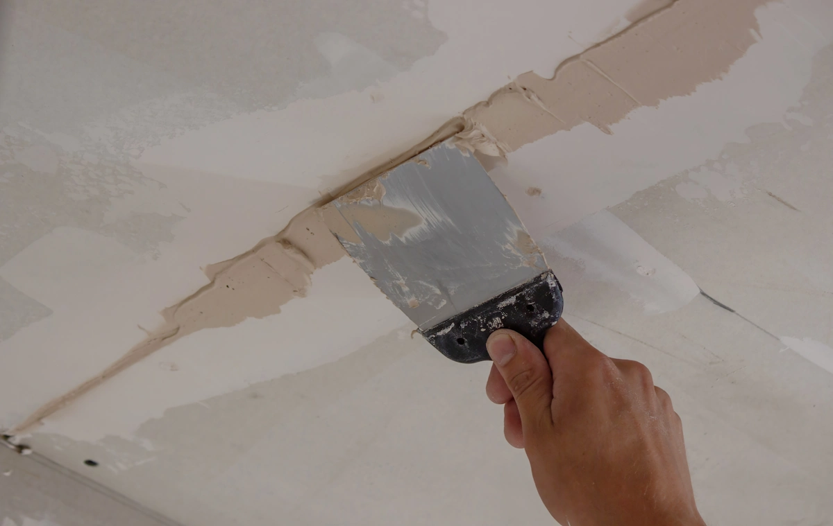 Un homme qui répare un plafond abimé