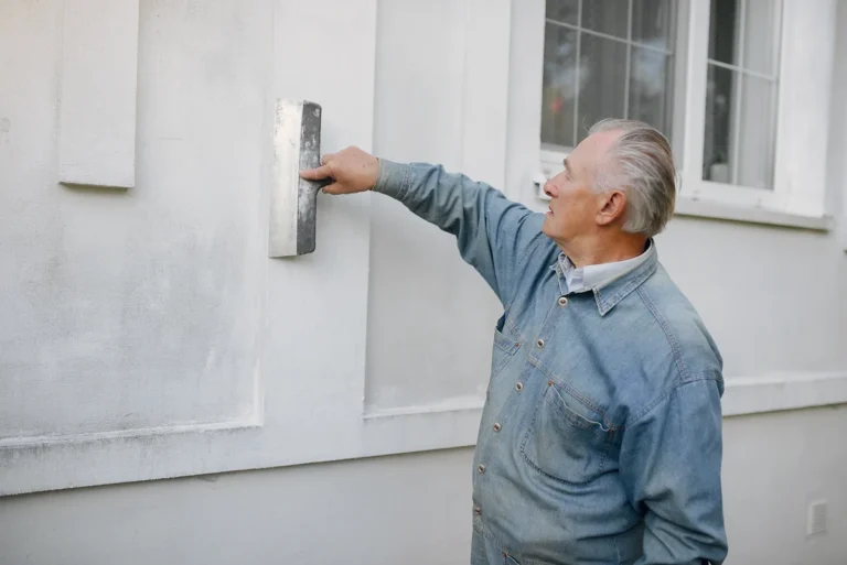 Un homme qui applique de l'enduit de façade exposée