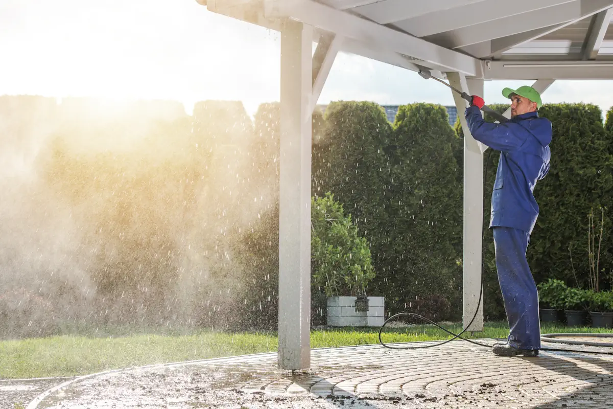 Un homme qui nettoie une pergola